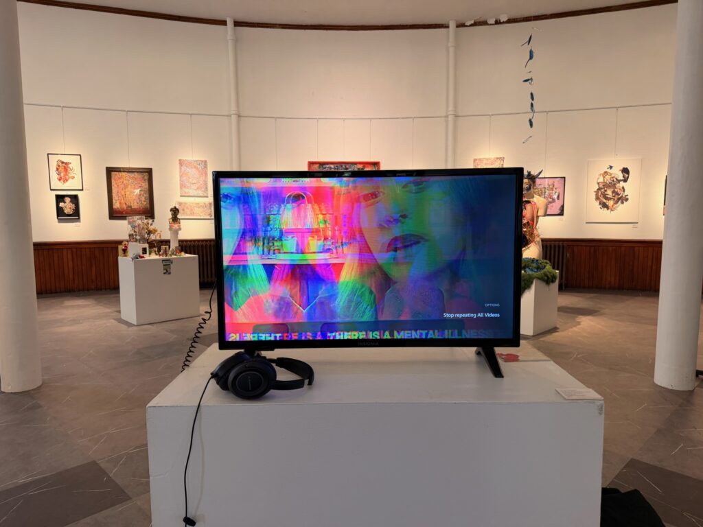 TV displaying videos with gallery art by Holly Dodge, Ellipse Elkshow, and I Cut People in the background.